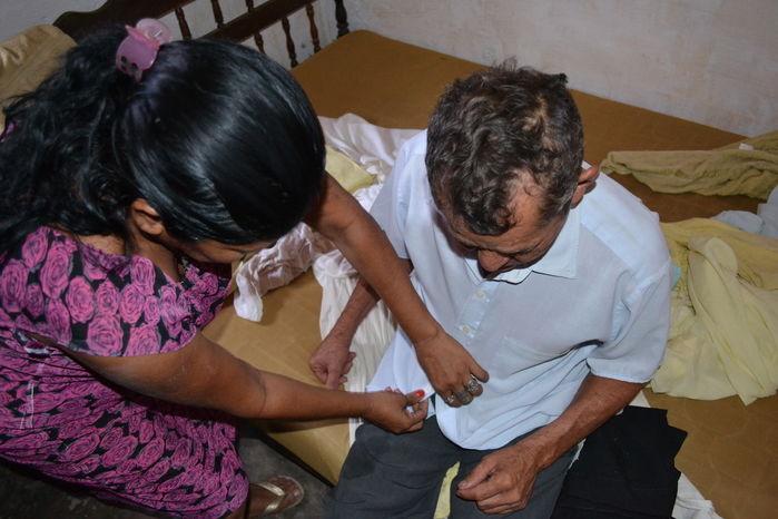 Idoso sendo amparado por familiares. (Foto: Kairo Amaral)