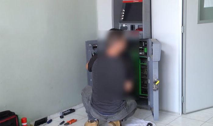 Funcionário do banco conserta o caixa eletrônico (Crédito: Reprodução)