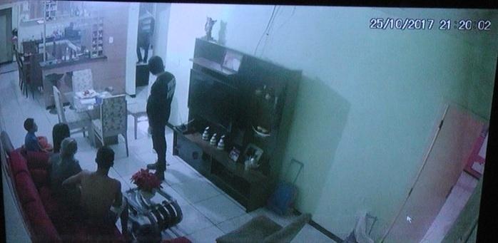 Um deles vigiava a família na sala da residência. (Crédito: Reprodução)