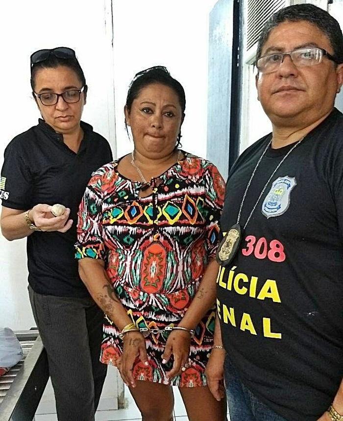Mulher presa ao lado dos agentes que realizaram o flagrante. (Crédito: Divulgação )