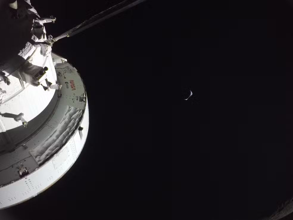 Foto: Reprodução/NASA - Nave Orion com a Terra crescente ao fundo